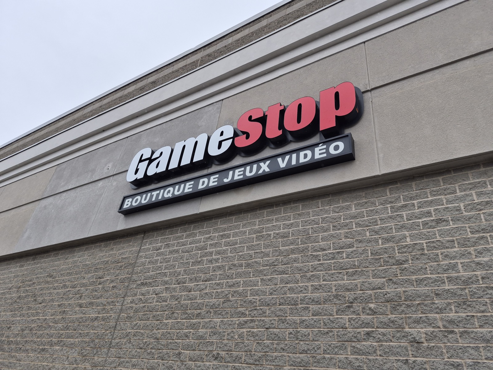 A GameStop sign seen from below against the sky