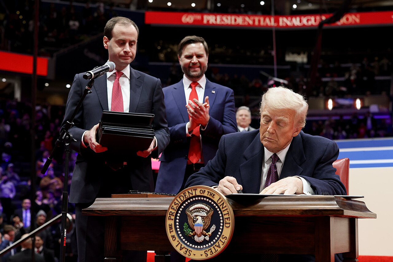 President Donald Trump signing executive orders at a desk