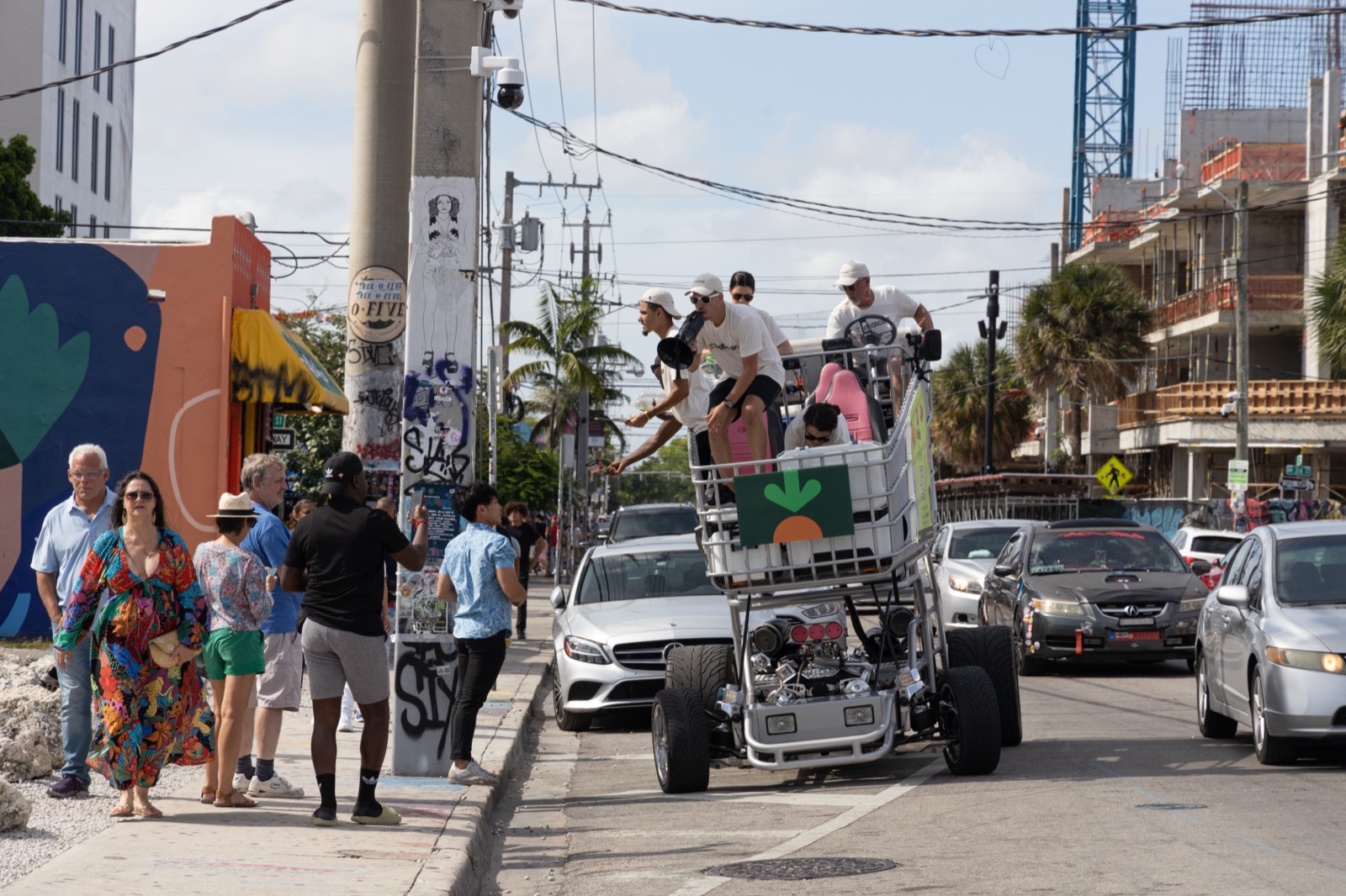 A promotional motorised shopping trolley bearing the Instacart carrot logo, with passengers on board, on a street in Miami, Florida